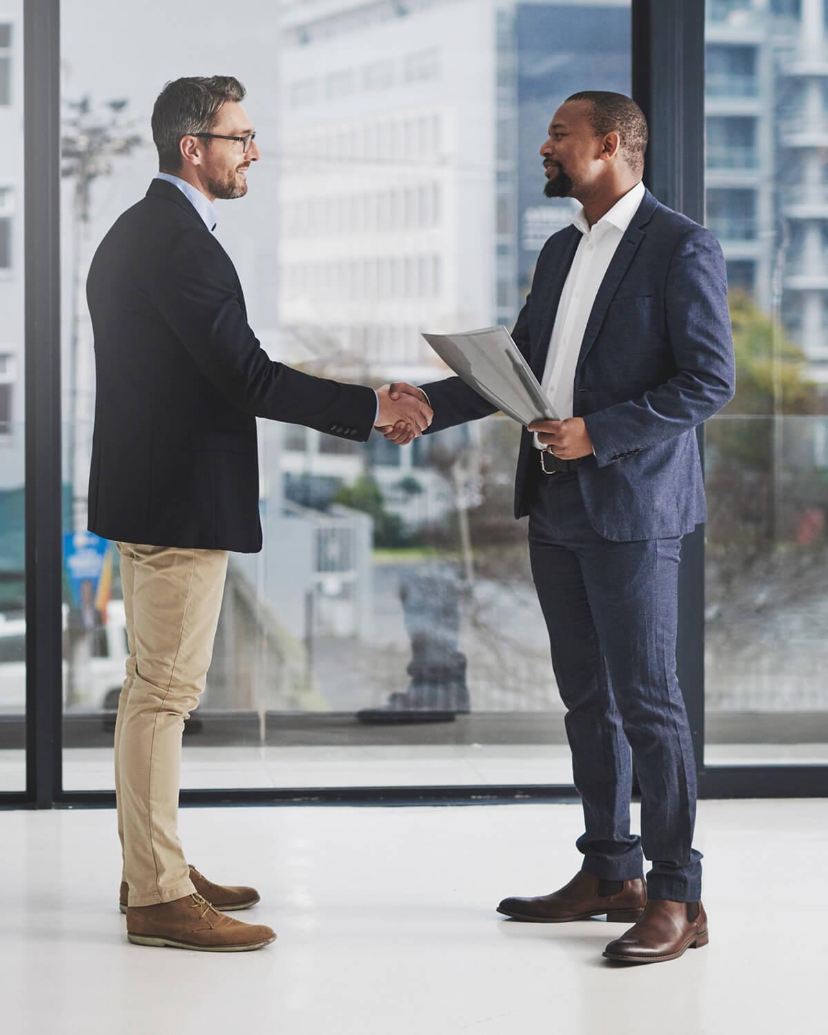 Two professionals shaking hands in a bright office