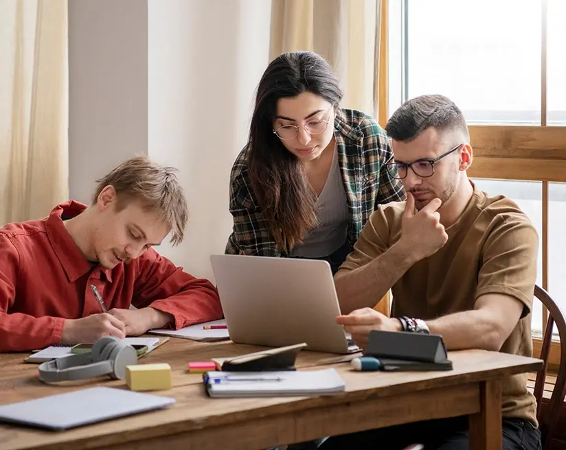Colleagues working around a laptop